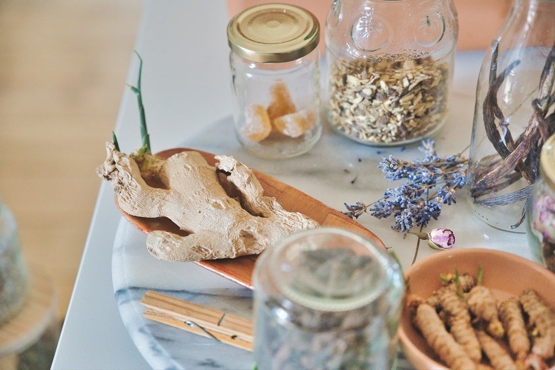 Ayurvediska örter, ingefära och kryddor i glasburkar och skålar